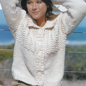 Puede incluir: Un cárdigan blanco de punto con cierre de botones y cuello. El cárdigan está hecho con un hilo grueso y tiene un corte holgado.