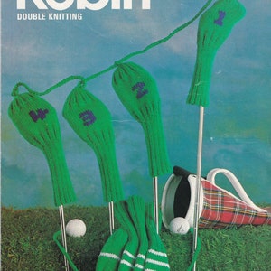 May include: Green knitted golf club covers with white stripes and numbers on a green grassy background. The covers are hanging on golf clubs with a plaid golf bag in the background. The text "Robin Double Knitting 2724" is at the top of the image.