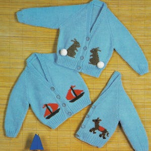 May include: Three blue knitted cardigans with different embroidered designs. One cardigan features two brown rabbits, another has two red sailboats, and the last one has a brown horse.