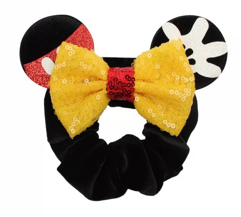 May include: Black velvet hair scrunchie with a yellow sequined bow and red and white Mickey Mouse ears.