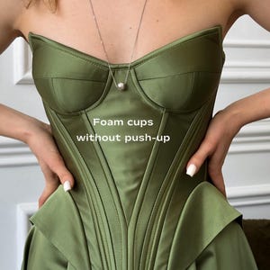 a woman in a green dress is holding her dress