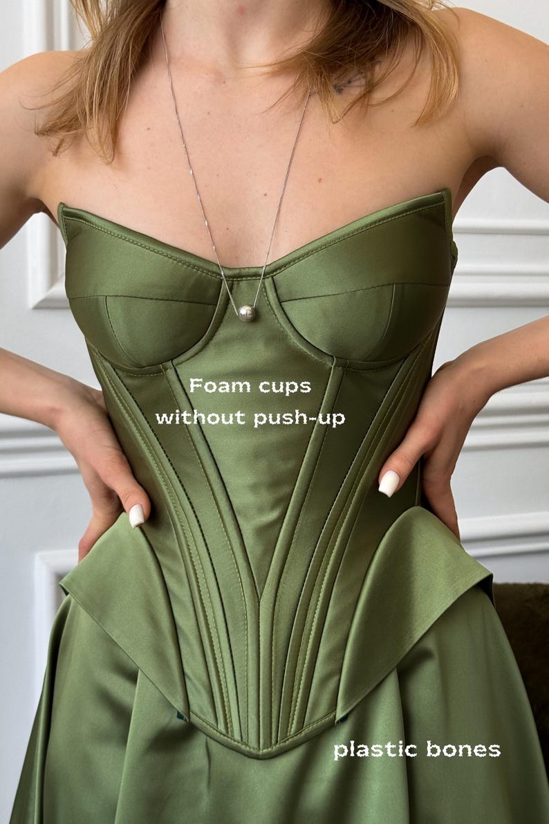 a woman in a green dress is holding her dress