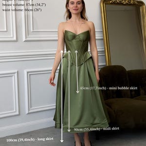Peut inclure: Ensemble corset et jupe midi vert olive. Le corset a un corsage structur&eacute;. La jupe midi mesure 90 cm. Le mod&egrave;le mesure 175 cm, avec un tour de poitrine de 87 cm et un tour de taille de 66 cm. La mini jupe est de 45 cm.