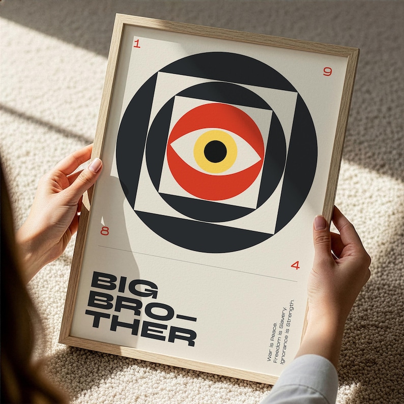 May include: A framed art print featuring a geometric design with a central eye motif in red, yellow, and black. The words "BIG BROTHER" are printed in bold, black letters. The print also includes the phrases "War is Peace, Freedom is Slavery, Ignorance is Strength."