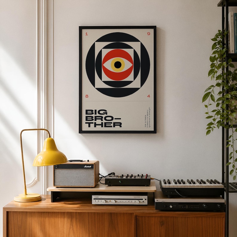 May include: A framed poster with a black border features a geometric eye design in red, black, and yellow, with the words "BIG BROTHER" below. The poster hangs above a wooden cabinet with a yellow lamp and audio equipment.