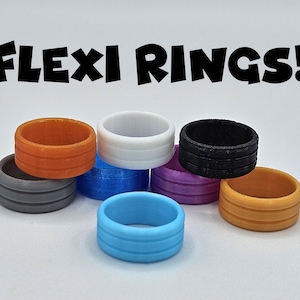 May include: A collection of colorful Flexi Rings in various shades, including orange, white, black, blue, and purple. Each ring has a grooved design. The text "FLEXI RINGS!" is displayed above the rings.