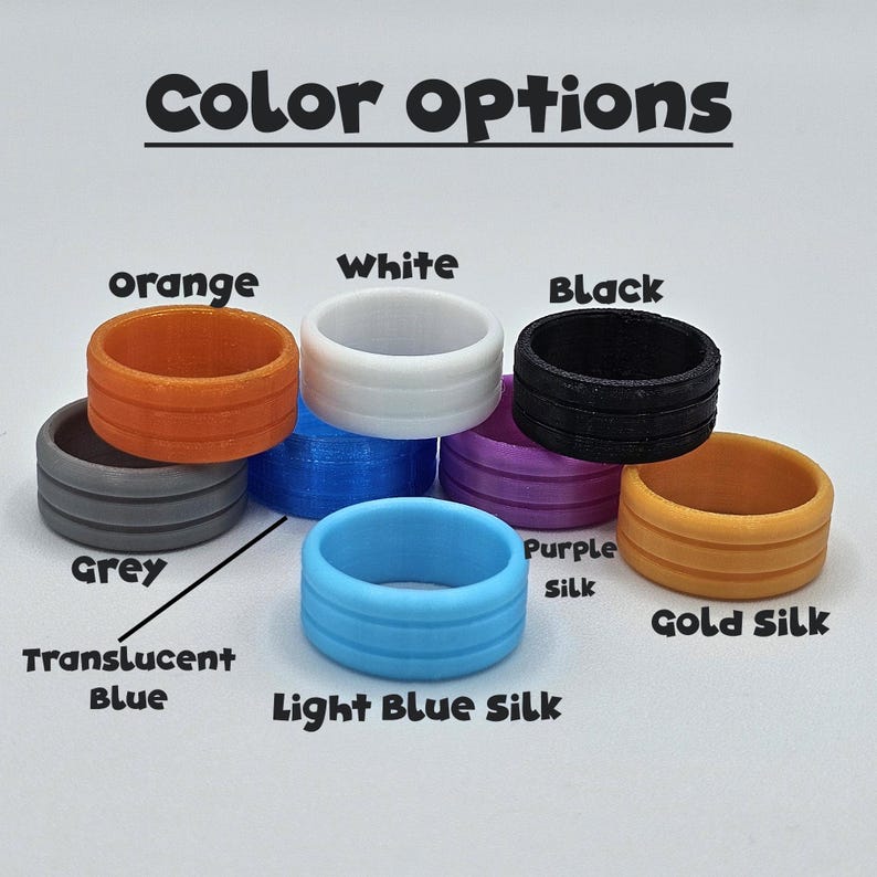 May include: A collection of colorful silicone rings in various shades, including orange, white, black, grey, translucent blue, light blue silk, purple silk, and gold silk. The text "Color options" is displayed above the rings.