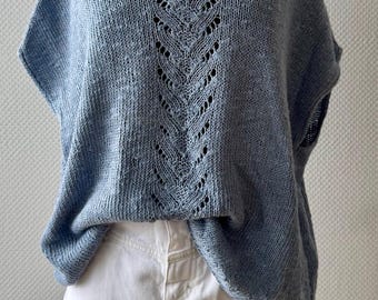 May include: A light blue knitted top with a lace pattern on the back. The top has short sleeves and a relaxed fit.