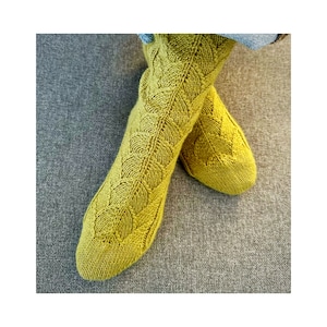 May include: A pair of yellow knitted socks with a leaf pattern.