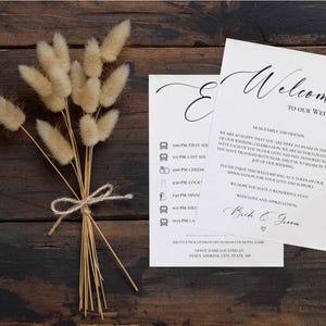 May include: A wedding welcome sign with a white background and black text. The sign includes a welcome message, a list of wedding events with times, and a shuttle pick-up location. The text reads: "Welcome to our wedding. Dear family and friends, We are so happy that you are here to share in the joy of our wedding celebration. We are so fortunate to have each of you in our lives and feel honored that you have traveled both near and far to make in the joy of our wedding. Please enjoy this welcome bag as a token of our appreciation for your love and support. We hope you have a wonderful stay! With love and appreciation, Bride & Groom. Shuttle pick-up/drop off in front of hotel name. Venue name located at venue address, city, state, zip."