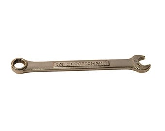 May include: A silver Craftsman combination wrench. The wrench has a closed end and an open end, both marked with "3/8". The Craftsman logo is printed on the wrench.