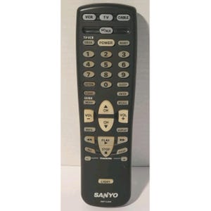 May include: A black Sanyo remote control with numerous buttons for TV, VCR, and cable functions. The remote has buttons for power, volume, channel selection, and playback controls. The model number AMT-U200 is printed at the bottom.