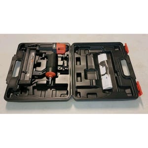 May include: A black tool case, open to reveal a pneumatic nailer and accessories. The nailer is black and red. The case has red latches and compartments for the nailer and other tools. The case is designed to hold the nailer securely.