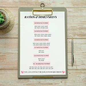 May include: A white clipboard with a gray background and gold binder clip. The clipboard has a list of different paper sizes and their corresponding dimensions in inches and centimeters. The text on the clipboard reads "Ratios & Dimensions".
