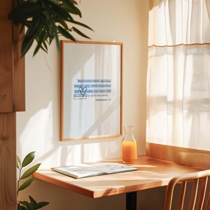 May include: A framed inspirational quote on a white wall with a wooden desk and a glass pitcher of orange juice. The quote reads: "Don't worry about anything instead, pray about everything Tell God what you need, and thank God for all he has done. Philippians 4:6"