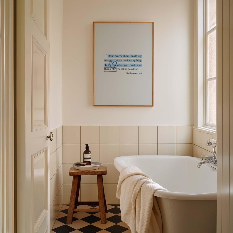 May include: A white bathtub with a white towel on the side, a wooden stool with a bottle of soap and a tray on top, and a framed print with the text "Don't worry about anything instead pray about everything Tell God what you need, and thank Him for all He has done. Philippians 4" hanging on the wall above the bathtub.