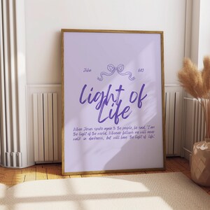 May include: A purple and white printable wall art print with a quote from the Bible, John 8:12, "When Jesus spoke again to the people, he said, 'I am the light of the world. Whoever follows me will never walk in darkness, but will have the light of life!'".