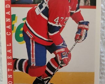 May include: A hockey trading card featuring a player in a red, white, and blue uniform with the number 47 on the front. The card is from the Score brand and features the Montreal Canadiens logo. The player's name is Patrice Brisebois and his position is D.
