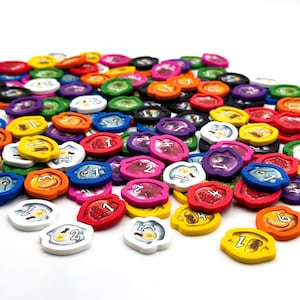 May include: A collection of colorful game tokens with numbers and images. The tokens are made of wood and have a variety of designs, including fruits, vegetables, and animals.