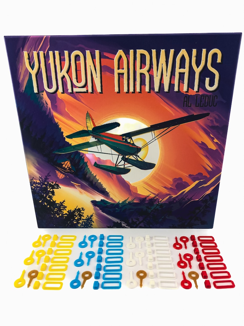May include: A board game box with the title "Yukon Airways" and a scenic illustration of a seaplane flying over mountains at sunset. Includes various colored game pieces in yellow, blue, white, and red.