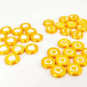 Könnte beinhalten: Ein Set aus drei Keramikbechern mit gesprenkelter, matter Oberfläche. Die Becher sind in Creme-, Hellgrau- und Dunkelgrautönen gehalten. Jeder Becher hat ein schlichtes, minimalistisches Design.