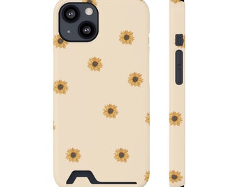 May include: A cream-colored phone case with a pattern of small yellow sunflowers. The case has a cutout for the camera lens and a black bumper.