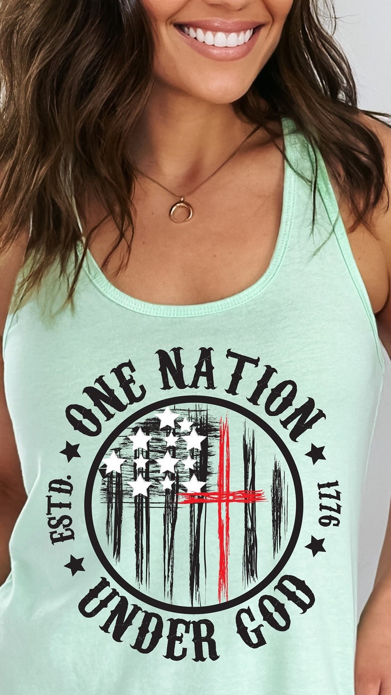 May include: A light green tank top with a black and red circle graphic. The graphic features a stylized American flag with a red cross and the text "ONE NATION UNDER GOD ESTD. 1776".