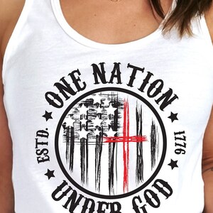 May include: White tank top with a black and red graphic print of a stylized American flag with the text "ONE NATION ESTD. 1776 UNDER GOD".