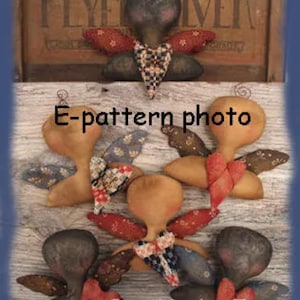 Può includere: Cinque angeli in tessuto di stile primitivo fatti a mano con le ali, ognuno con un diverso motivo e colore del tessuto. Gli angeli sono disposti su una superficie di legno con il testo "E-pattern photo" e "Sweet Meadows Farm" visibile.