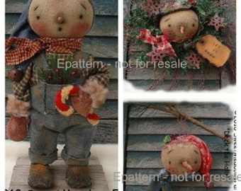 May include: Three handmade rag doll ornaments with a winter theme. The first doll is wearing overalls and holding a candy cane. The second doll is wearing a red and white hat and is part of a wreath. The third doll is wearing a red hat and scarf and is holding a stick.