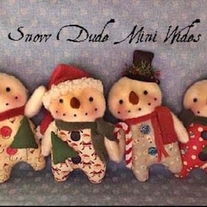 May include: Four handmade snowman dolls with button eyes, carrot noses, and painted rosy cheeks. Each snowman wears a different outfit, including hats, scarves, and patterned clothing. The text "Snow Dude Mini Wides" is above the snowmen.