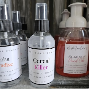 May include: Clear spray bottles with black spray nozzles and white labels. One label reads "Cereal Killer" with "Eliminator Room Spray" and scent details. Another bottle reads "Aloha Paradise". The bottles are 4 oz / 120 ml.