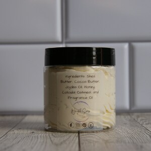 K&ouml;nnte beinhalten: Ein wei&szlig;es Glas mit schwarzem Deckel, gef&uuml;llt mit einer wei&szlig;en Creme. Das Etikett auf dem Glas lautet "ingredients Shea Butter, Cocoa Butter, Jojoba Oil Honey, Colloidal Oatmeal, and Fragrance Oil" und "Wight Sur" mit Social-Media-Symbolen.