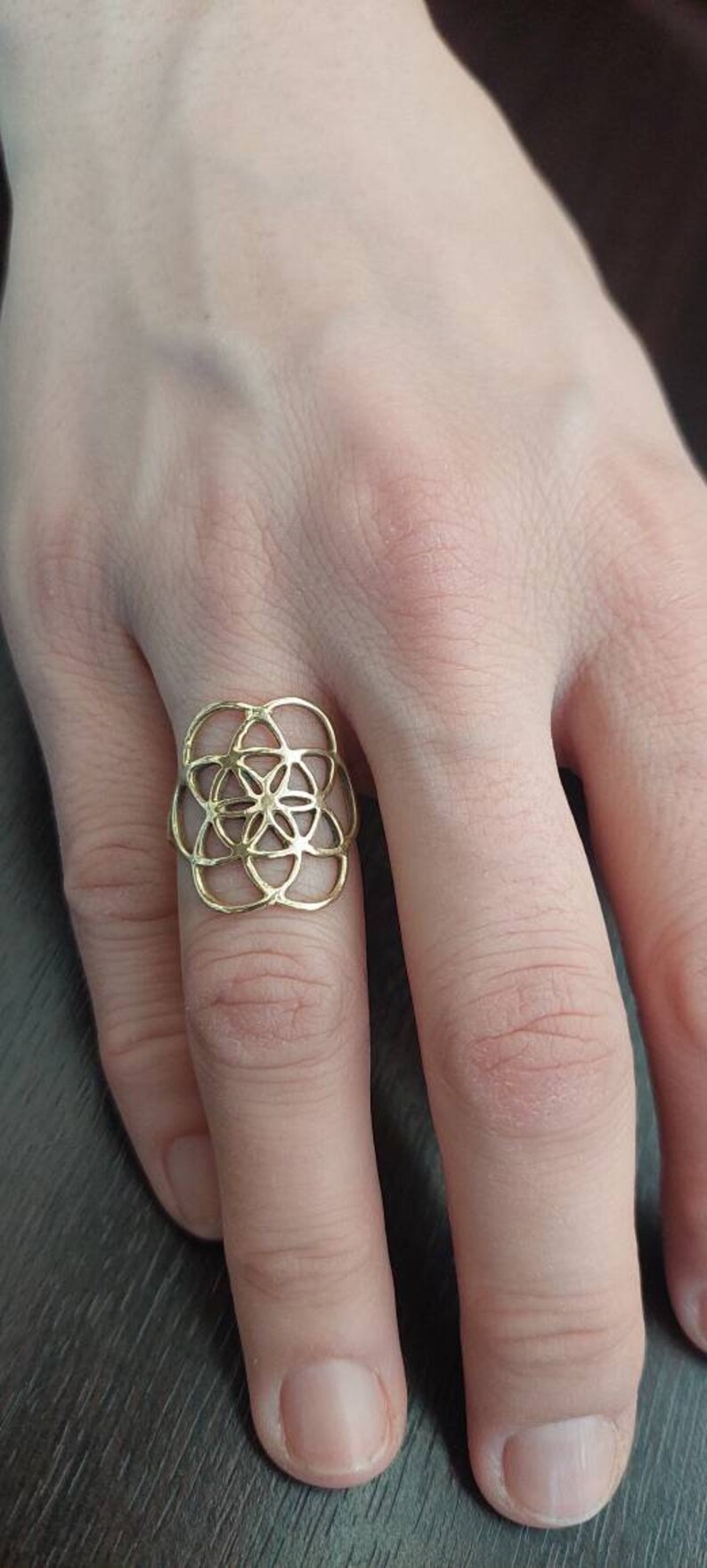 Puede incluir: Un anillo de oro con un dise&ntilde;o geom&eacute;trico que se asemeja a una flor.