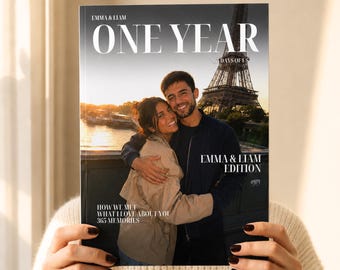 May include: A custom photo book cover titled ONE YEAR 365 DAYS OF US featuring a couple embracing in front of the Eiffel Tower at sunset. The text reads EMMA & LIAM, EMMA & LIAM EDITION, HOW WE MET, WHAT I LOVE ABOUT YOU, and 365 MEMORIES.