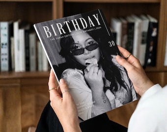 Könnte beinhalten: Ein schwarz-weißes Magazin-Cover mit dem Titel BIRTHDAY THE SARAH EDITION 30TH BIRTHDAY 2026, das eine Person mit Sonnenbrille beim Essen eines Snacks zeigt. Das Cover enthält den Text 30 und 30 & THRIVING sowie weiteren Text am unteren Rand.