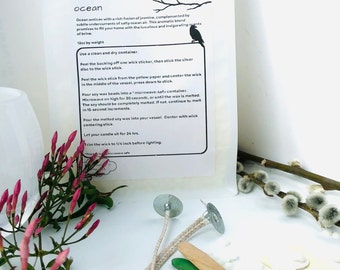May include: A white bag with instructions for making a soy candle. The bag has a black and white illustration of a bird on a branch. The text on the bag reads "Wild Stone organic soy candle wax ocean".