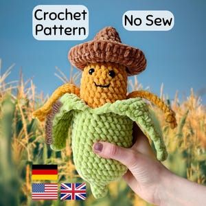 May include: A plush crochet corn toy with a brown hat, yellow kernels, and light green husks. The text "Crochet Pattern" and "No Sew" appear at the top. The corn has black safety eyes and a stitched smile, crafted from soft yarn.