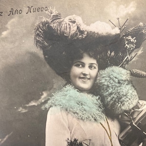 Cartolina d'epoca con felice anno nuovo spagnolo dei primi anni del 1900 Donna che porta regali