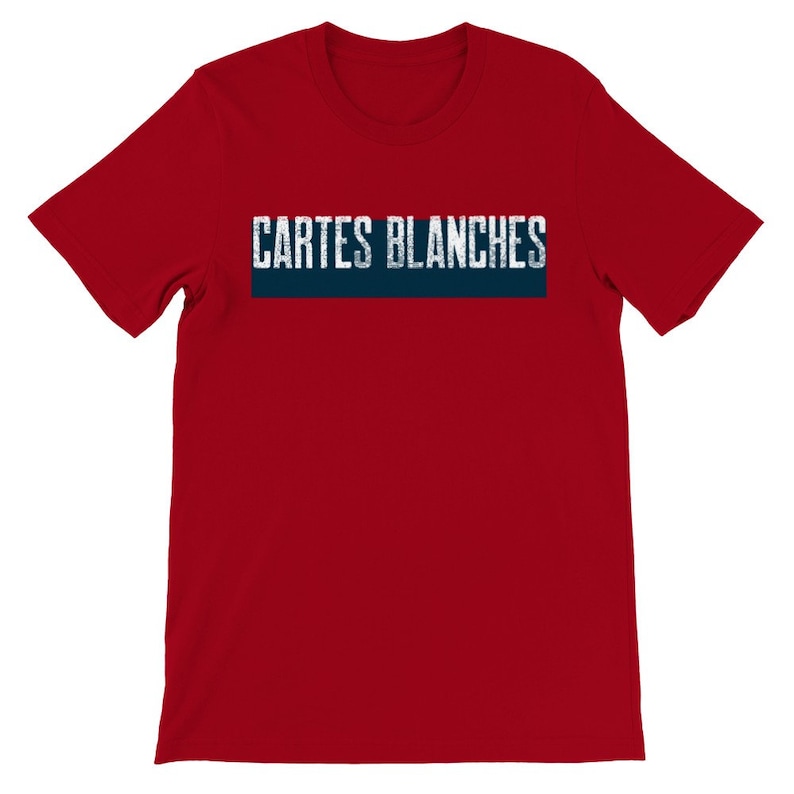 May include: Red short sleeve t-shirt featuring a navy blue horizontal banner with the text 'CARTES BLANCHES' in a distressed, white sans-serif font. The shirt is a classic crew neck style and appears to be made of a soft, comfortable fabric.