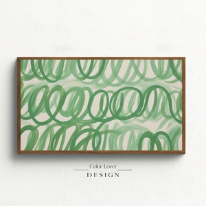 May include: Abstract art print with a green and white color scheme. The print features a series of overlapping, swirling lines in a green hue on a white background. The print is framed in a natural wood frame.