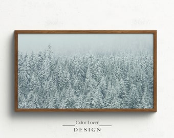 Könnte beinhalten: Gerahmter Kunstdruck mit einer Winterwaldszene. Das Bild zeigt schneebedeckte Nadelbäume unter einem nebligen Himmel. Der Rahmen ist braun und der Text "Color Lover DESIGN" befindet sich unten.