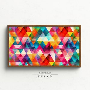 Puede incluir: Una impresión geométrica abstracta enmarcada con un patrón colorido de triángulos en tonos de rojo, naranja, amarillo, verde, azul, morado y rosa. El marco es de madera marrón.