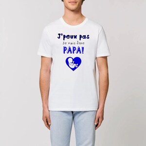 May include: White t-shirt with blue text that reads "J'peux Pas Je vais &ecirc;tre PAPA!" and a blue silhouette of a baby in a heart.