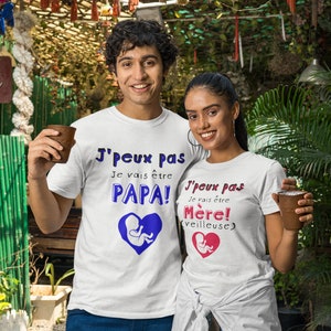 May include: A couple wearing white t-shirts with a blue and pink graphic of a fetus inside a heart. The text on the shirts reads "J'peux pas Je vais &ecirc;tre PAPA!" and "J'peux pas Je vais &ecirc;tre M&egrave;re! (veilleuse)".