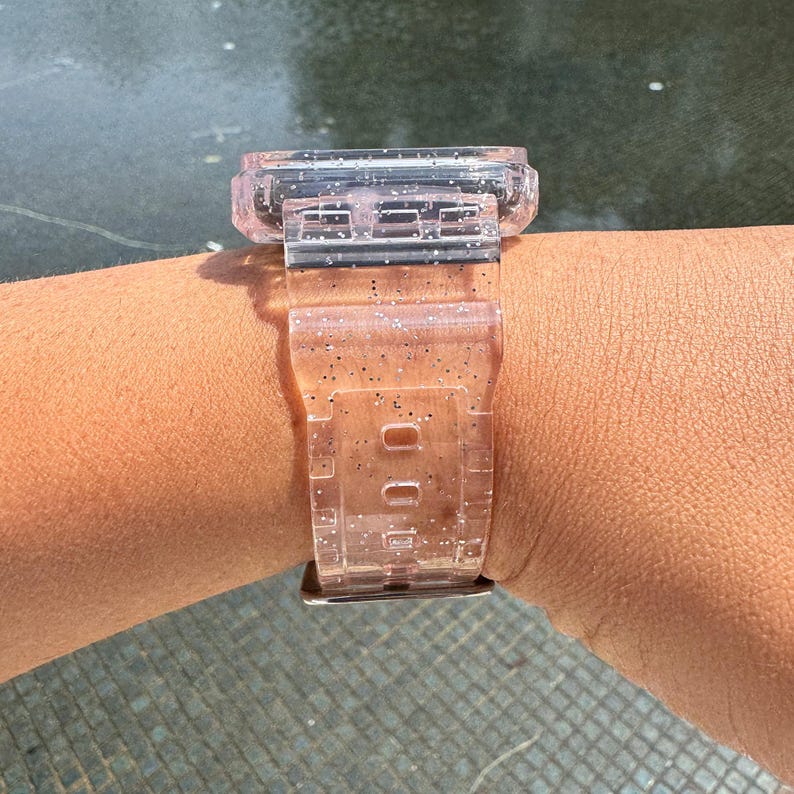 Pu&ograve; includere: Un cinturino per orologio trasparente rosa con glitter incorporati nella plastica. Il cinturino &egrave; progettato per un quadrante dell'orologio quadrato.