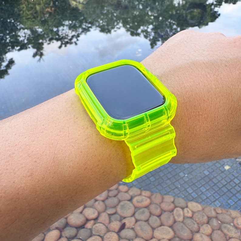 May include: A neon green smartwatch band and case. The band is made of a translucent material and is secured on the wrist. The watch face is black. The band is a bright, eye-catching accessory.