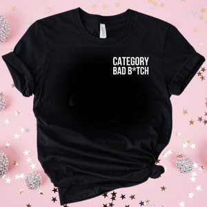 May include: Black t-shirt with white text that reads "CATEGORY BAD B*TCH"