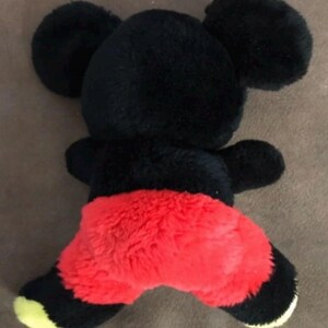May include: Black and red plush toy shaped like Mickey Mouse. The toy has large ears and a red, fuzzy bottom.