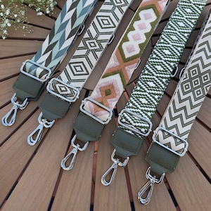 Peut inclure: Cinq sangles en tissu à motifs différents avec des fermoirs en métal argenté. Les sangles sont dans des tons de vert, blanc et marron.